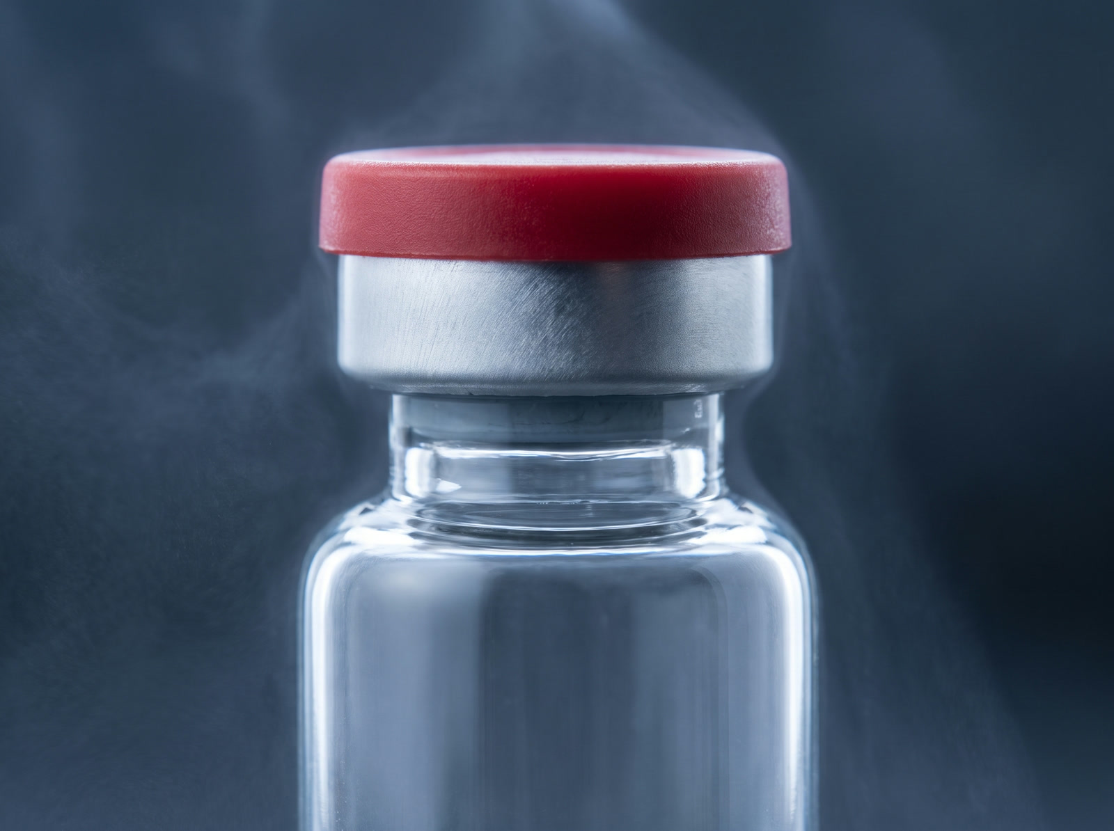Close-up of a sealed vial's red cap and grey stopper